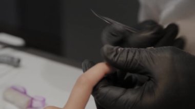 Profesyonel manikürcü adam özel makas ile cuticles kaldırır.