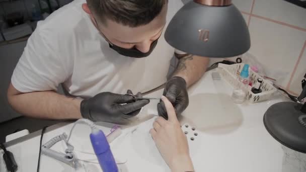 Professional manicurist man removes cuticles with special scissors. — Stock Video