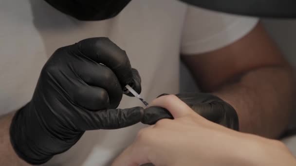 Professional manicurist man varnishes a girls nails. — Stock Video