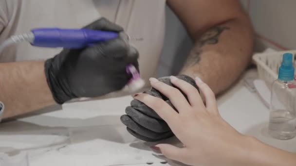 Professional manicurist man removes old nail polish from a girl using a special nail polish remover. — Stock Video