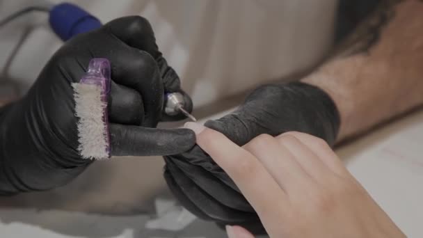 Professionele manicure man verwijdert oude nagellak van een meisje met behulp van een speciale nagellakremover. — Stockvideo