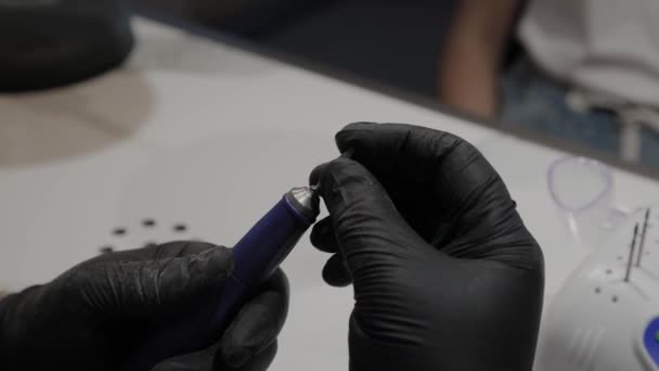 Hombre manicurista profesional inserta una punta en un quitaesmalte de uñas especial . — Vídeo de stock