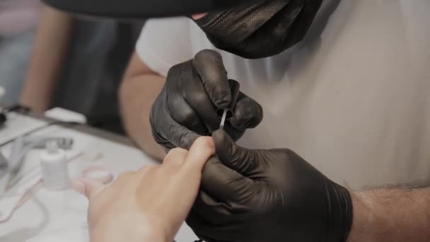 Professional manicurist man varnishes a girls nails. — Stock Video