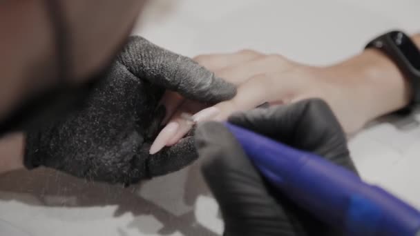 Професійний манікюрник видаляє старий лак для нігтів з дівчини, використовуючи спеціальний лак для нігтів . — стокове відео