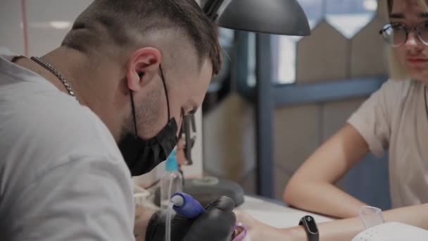 Professionelle Maniküre Mann entfernt alten Nagellack von einem Mädchen mit einem speziellen Nagellackentferner. — Stockvideo