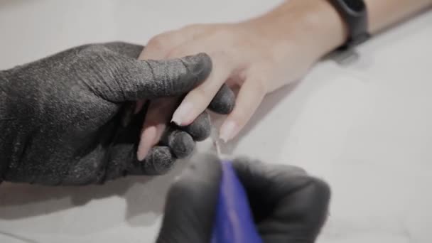 Uomo manicure professionale rimuove vecchio smalto da una ragazza con uno speciale smalto rimozione . — Video Stock