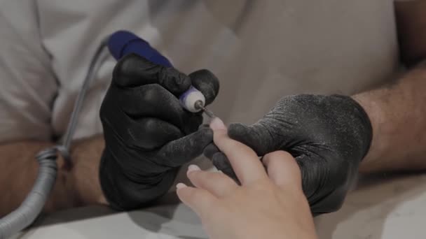 Professionelle Maniküre Mann entfernt alten Nagellack von einem Mädchen mit einem speziellen Nagellackentferner. — Stockvideo