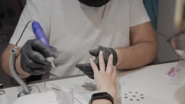 Manucure professionnel homme enlève vieux vernis à ongles d'une fille à l'aide d'un dissolvant spécial vernis à ongles . — Video