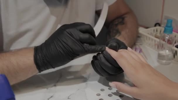 Professionale manicure uomo lucida e liscia le unghie delle ragazze con una lima per unghie . — Video Stock