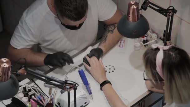 Professionale manicure uomo lucida e liscia le unghie delle ragazze con una lima per unghie . — Video Stock