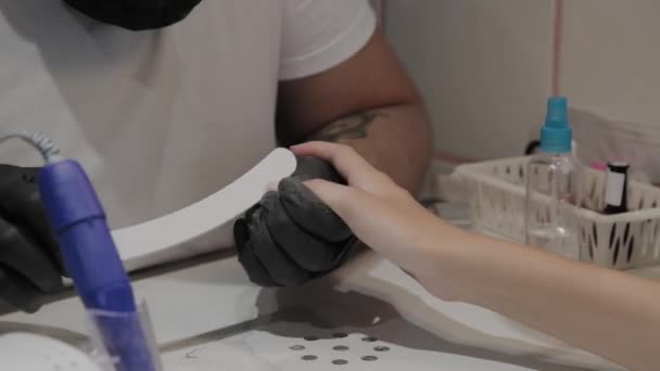 Professionale manicure uomo lucida e liscia le unghie delle ragazze con una lima per unghie . — Video Stock