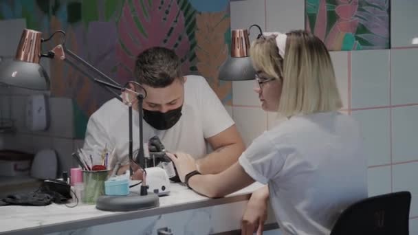 Professionele manicure man verwijdert oude nagellak van een meisje met behulp van een speciale nagellakremover. — Stockvideo