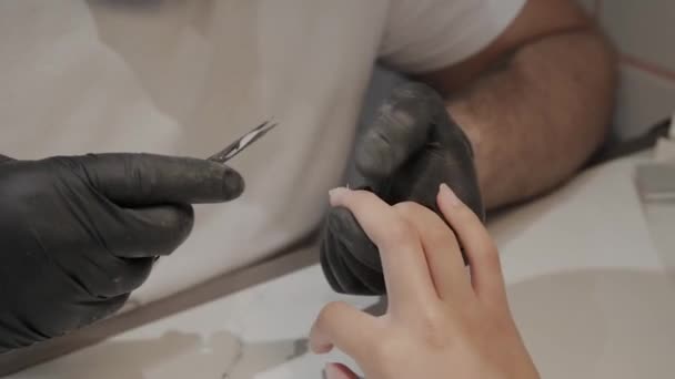 Professional manicurist man removes cuticles with special scissors. — Stock Video