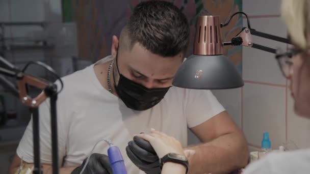 El hombre manicurista profesional barniza las uñas de la muchacha . — Vídeos de Stock