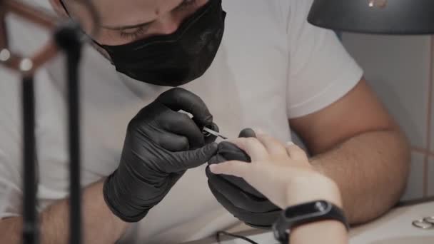 El hombre manicurista profesional barniza las uñas de la muchacha . — Vídeo de stock
