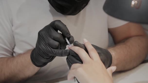 El hombre manicurista profesional barniza las uñas de la muchacha . — Vídeos de Stock