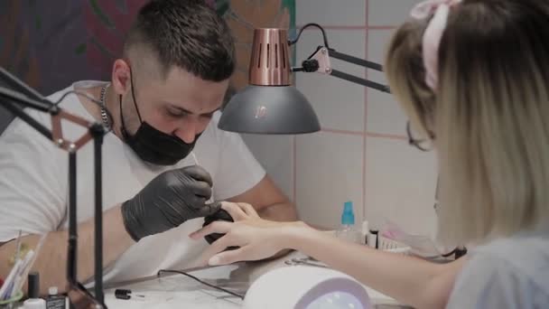 Professional manicurist man varnishes a girls nails. — Stock Video