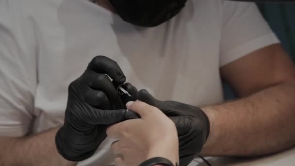 El hombre manicurista profesional barniza las uñas de la muchacha . — Vídeo de stock