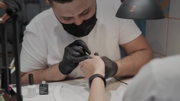 El hombre manicurista profesional barniza las uñas de la muchacha . — Vídeos de Stock