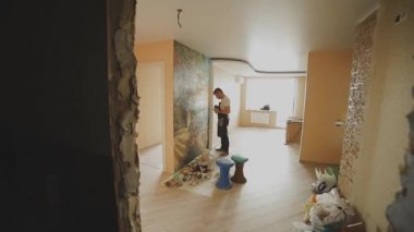 Profesyonel sanatçı dairede duvara bir resim boyar.