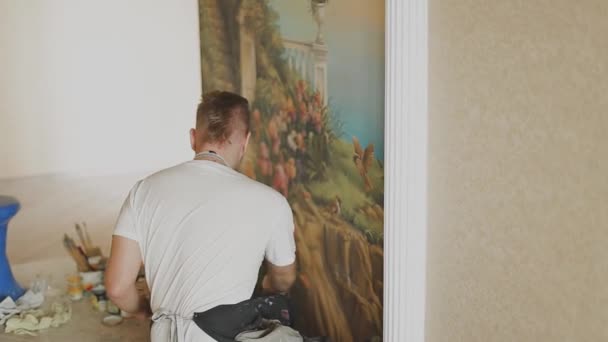 Επαγγελματίας καλλιτέχνης ζωγραφίζει μια εικόνα στον τοίχο στο διαμέρισμα. — Αρχείο Βίντεο
