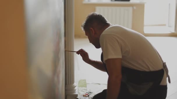 Professionele kunstenaar schildert een foto op de muur in het appartement. — Stockvideo