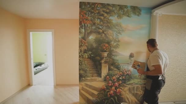 Artista professionista dipinge un quadro sul muro in appartamento . — Video Stock