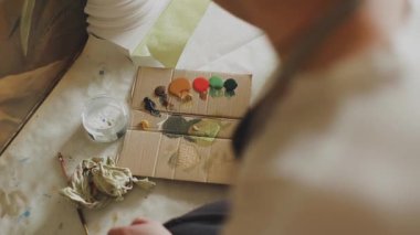 Profesyonel sanatçı dairede duvara bir resim boyar.