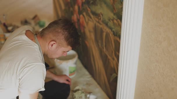Artista profissional pinta um quadro na parede do apartamento . — Vídeo de Stock