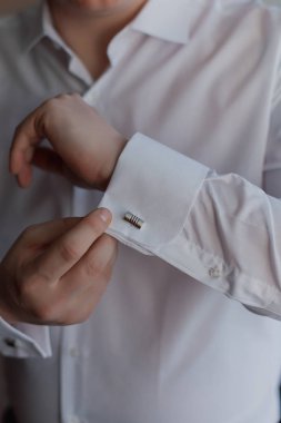 Yakın bir el adamın nasıl giyer beyaz gömlek ve kol düğmesi.