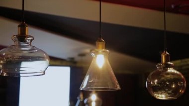 Vintage ve retro sarı ampul geceleri kafede karanlık arka plan üzerinde asılı. Bistro ve restoranda birçok lüks ışık lambası dekoratif endüstriyel loft tarzı.