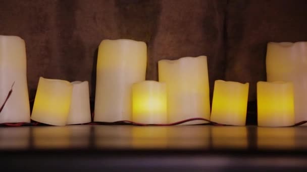 Lindas velas acesas no crepúsculo sobre a mesa . — Vídeo de Stock