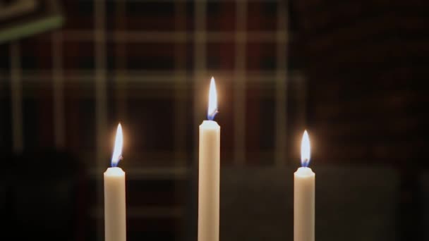 Красиві палаючі свічки в сутінках на столі . — стокове відео