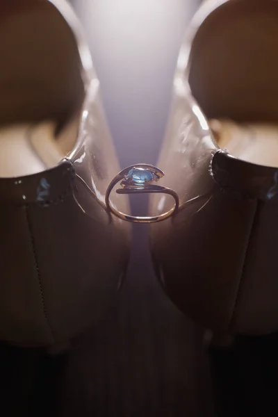 Sapatos de mulheres de casamento com um anel de casamento iluminado pela luz da foto . — Fotografia de Stock