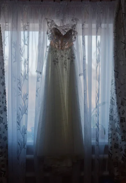 Hermoso vestido de novia colgando en la ventana . —  Fotos de Stock