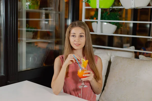 Красивая девушка с ярким свежим коктейлем в кафе . — стоковое фото