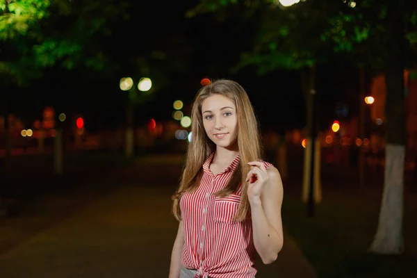 Όμορφο κορίτσι στο σοκάκι στο πάρκο το βράδυ. — Φωτογραφία Αρχείου