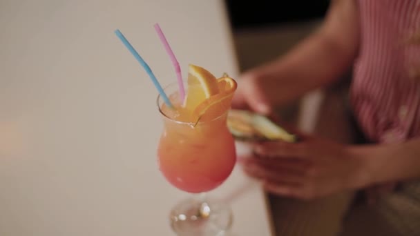 Menina bonita com um belo cocktail de noite brilhante fresco brilhante em um café . — Vídeo de Stock
