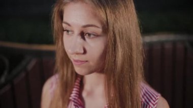 Bir parkta akşam bir bankta güzel genç kız.