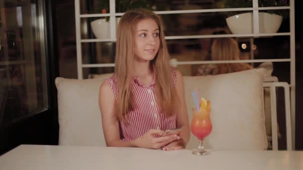 Bella ragazza con una bella fresca brillante cocktail serale in un caffè . — Video Stock