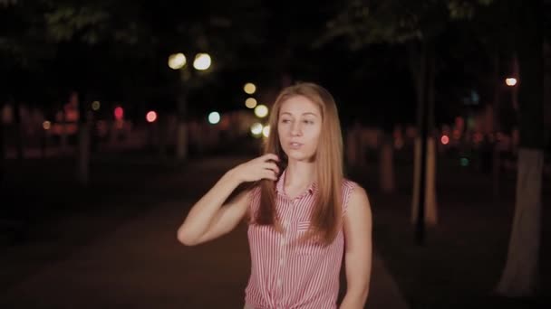 Hermosa chica alegre en el callejón en el parque nocturno . — Vídeo de stock