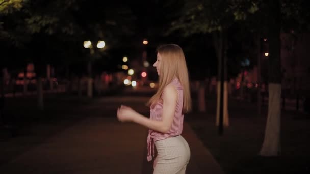 Beautiful cheerful girl in the alley in the evening park. — Stock Video
