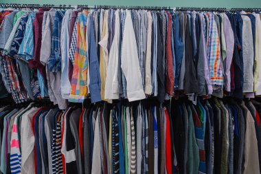 Bir mağazada askıları renkli giysiler.