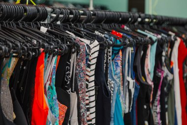 Bir mağazada askıları renkli giysiler.