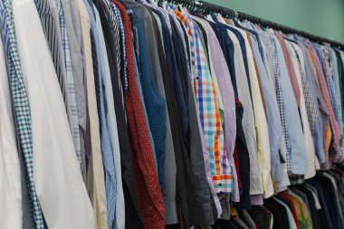 Bir mağazada askıları renkli giysiler.