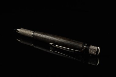 Siyah ayna arka plan üzerinde güzel el yapımı kalem.