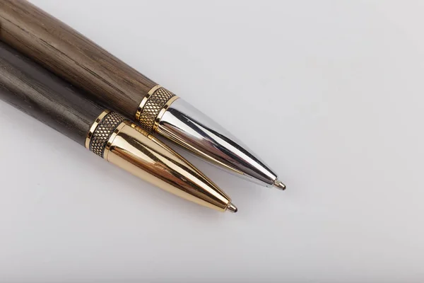 Dos bolígrafos hechos a mano de madera y metal sobre un fondo blanco . — Foto de Stock