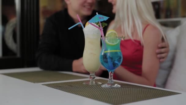 Schönes Mädchen und Mann mit frischen Cocktails im Abendcafé. — Stockvideo