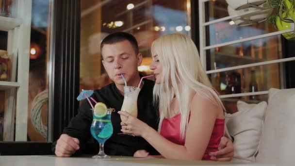 Belle fille et mec avec des cocktails frais dans le café du soir . — Video