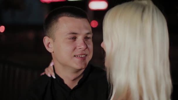 Happy couple of lovers on a bench in the evening on an alley in the city. — Stock Video